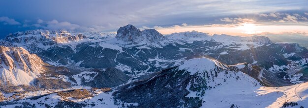 Colpo panoramico delle montagne coperte di neve al tramonto