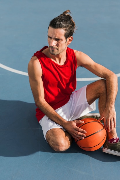 Colpo pieno del ragazzo con la palla di pallacanestro