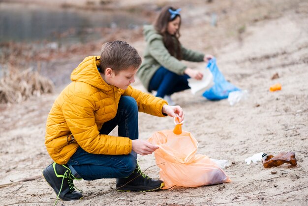 Colpo pieno di bambini che puliscono il terreno