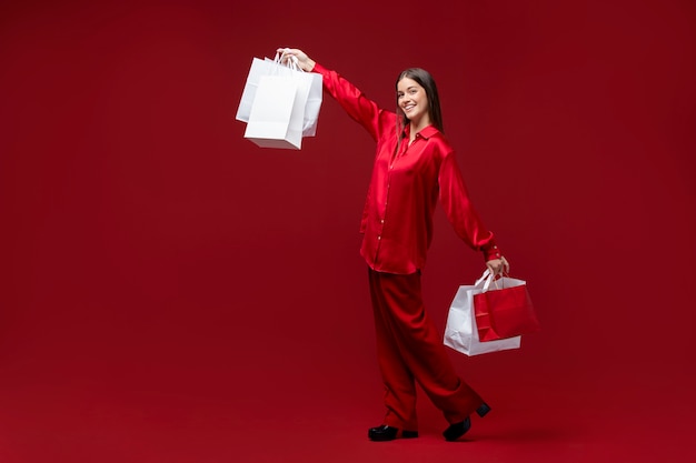 Colpo pieno donna felice che tiene le borse della spesa