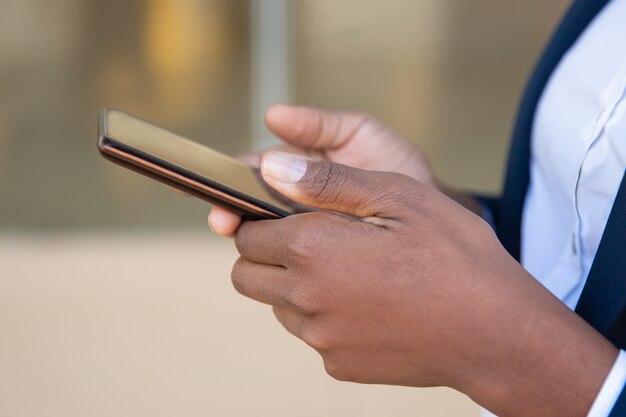 Colpo potato della donna di affari che per mezzo dello smartphone