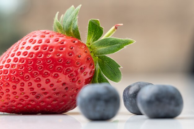 Colpo selettivo del primo piano della fragola e dei mirtilli maturi