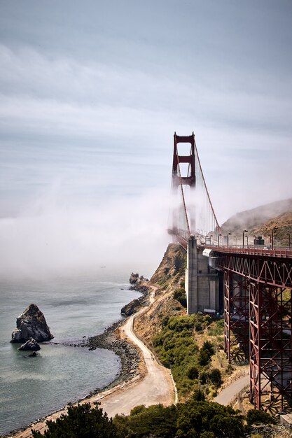 Colpo verticale del Golden Gate Bridge contro un nebbioso cielo blu a San Francisco, California, USA