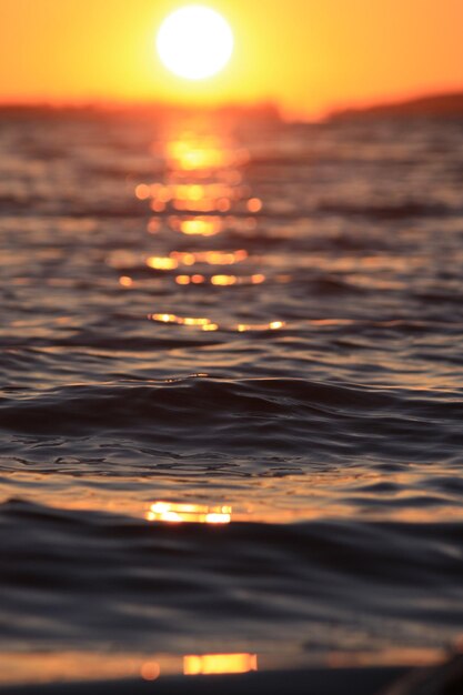 Colpo verticale del mare sfocato durante il tramonto ottimo per lo sfondo