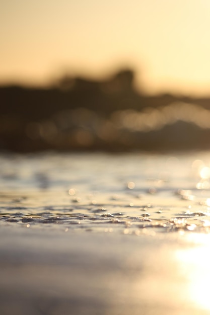 Colpo verticale del mare sfocato durante il tramonto ottimo per lo sfondo