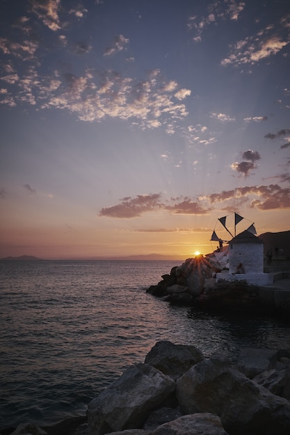 Colpo verticale del mulino a vento di Ormos Egialis nell'isola di Amorgos, Grecia al tramonto