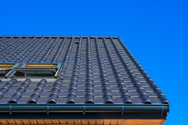 Colpo verticale del primo piano di angolo basso del tetto nero di un edificio