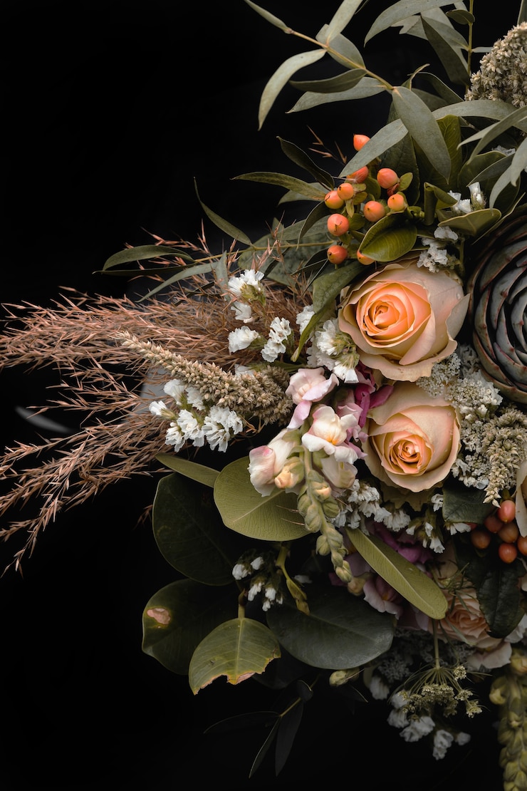 Foto gratuito colpo verticale del primo piano di un lussuoso bouquet di rose arancioni e marroni su sfondo nero