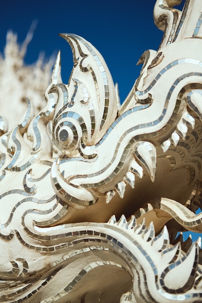 Colpo verticale del primo piano di una statua del drago nel tempio bianco a Chiang Rai, Thailandia