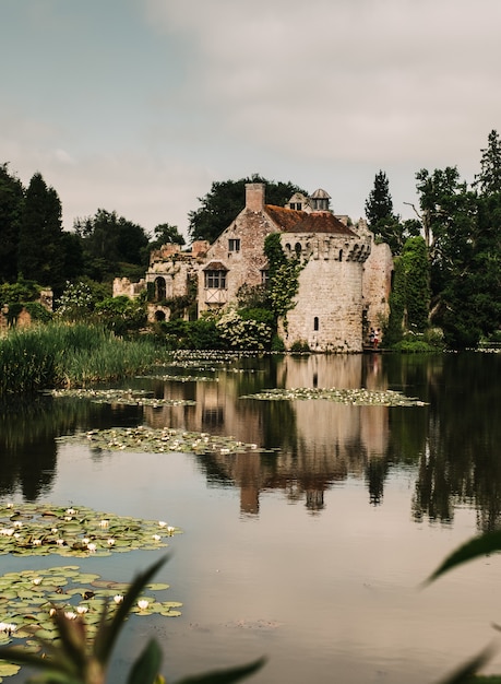 Colpo verticale del riflesso di un antico castello su un bellissimo laghetto circondato da alberi
