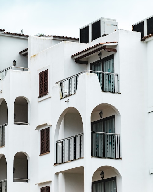 Colpo verticale dell'edificio bianco con diversi balconi