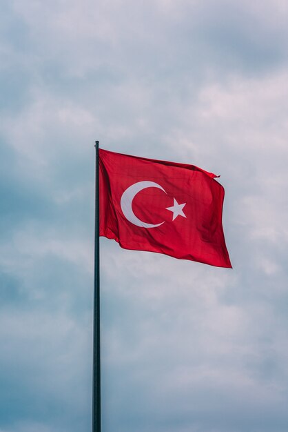 Colpo verticale della bandiera della Turchia fluttuante nell'aria