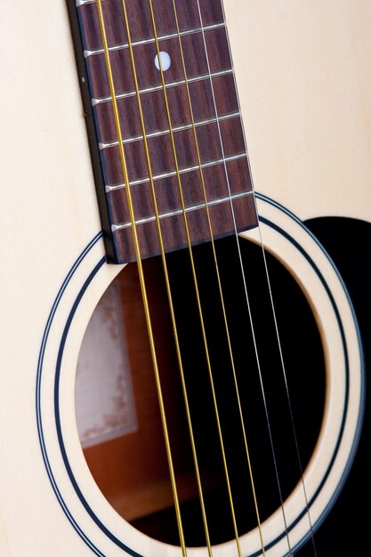 Colpo verticale delle corde di una chitarra bianca durante il giorno