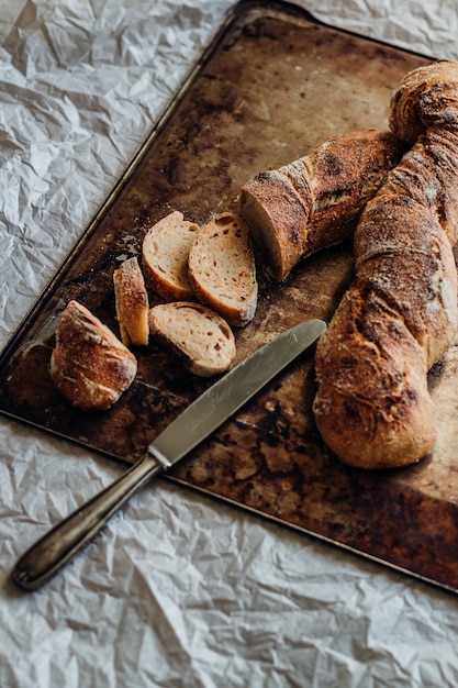 Colpo verticale delle fette di pane delle baguette su un tagliere