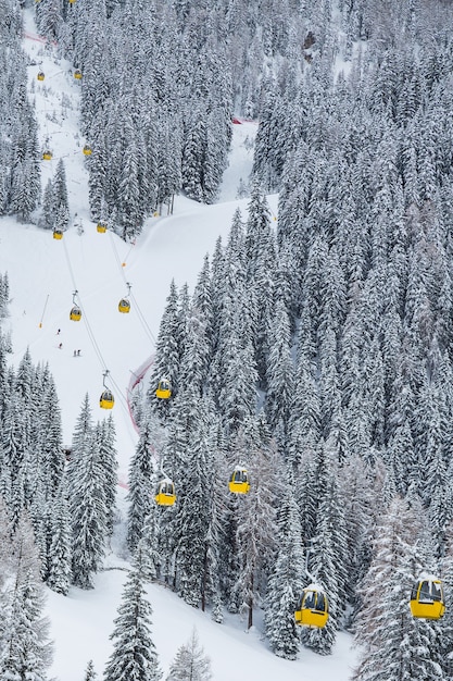 Colpo verticale delle funivie gialle in montagna durante l'inverno