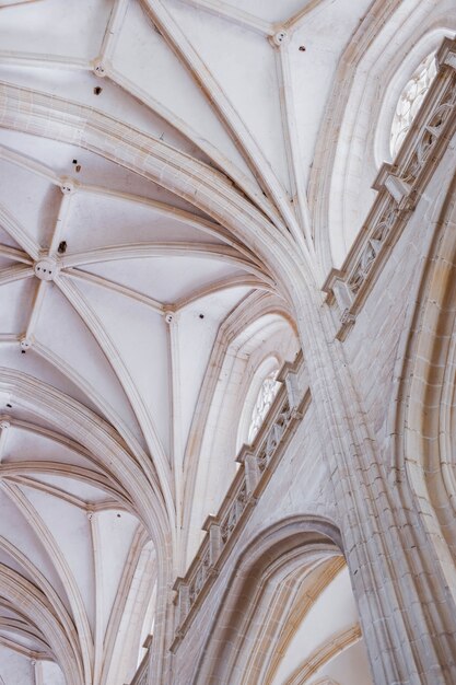 Colpo verticale di angolo basso delle colonne bianche e del soffitto di una vecchia costruzione