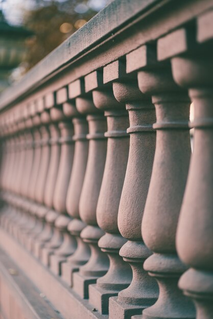 Colpo verticale di colonne di recinzione di un ponte sotto la luce del sole con uno sfondo sfocato