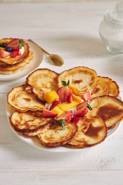 Colpo verticale di deliziose frittelle con frutta nel mezzo