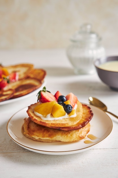 Colpo verticale di frittelle con frutta in alto