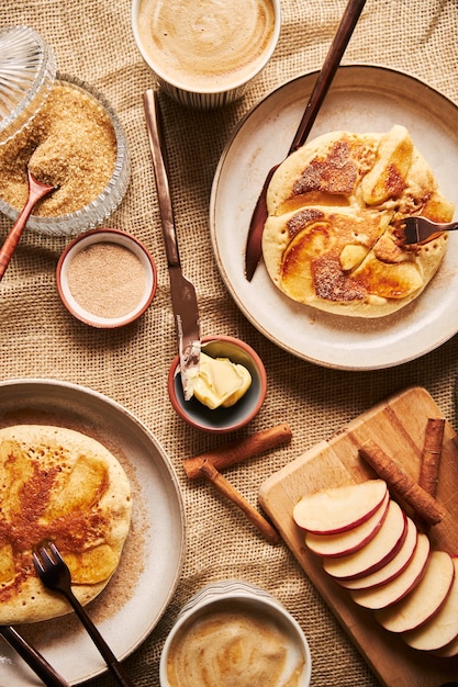 Colpo verticale di frittelle di mele con mele di caffè e altri ingredienti da cucina sul tavolo