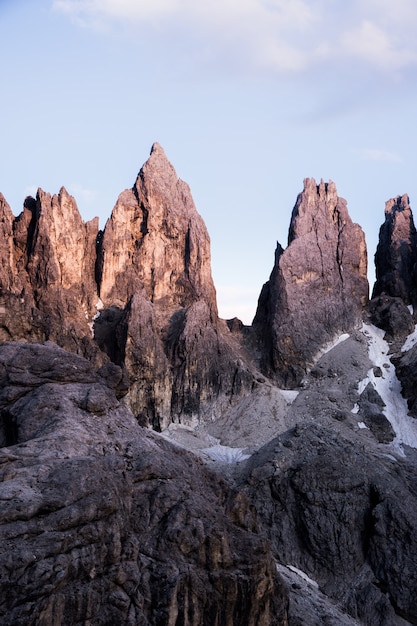 Colpo verticale di grandi rocce in cima ad una montagna con un chiaro cielo in