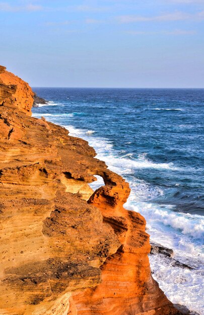 Colpo verticale di rocce circondate dal mare sotto la luce del sole nelle Isole Canarie