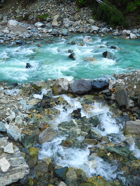 Colpo verticale di rocce in un ruscello che scorre acqua