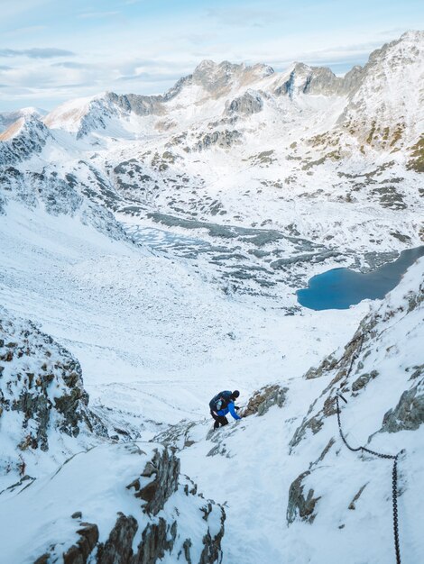 Colpo verticale di un alpinista che scala i Monti Tatra ricoperti di neve in Polonia