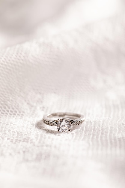 Colpo verticale di un bellissimo anello di diamanti su una superficie bianca