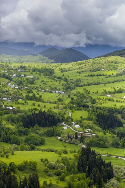 Colpo verticale di un bellissimo villaggio sulle colline ricoperte di erba