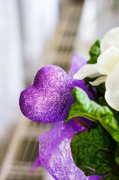 Colpo verticale di un cuore viola decorativo con glitter