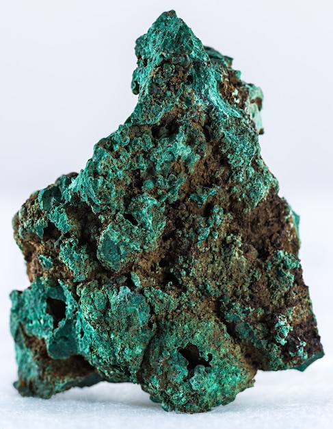 Colpo verticale di un minerale di malachite isolato su uno sfondo bianco