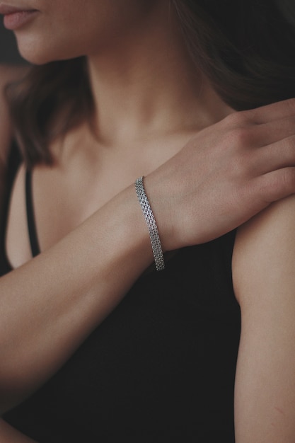 Colpo verticale di una giovane donna che indossa un bellissimo braccialetto d'argento