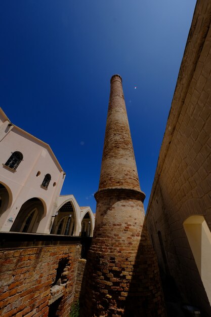 Colpo verticale di una torre di mattoni vicino a una menzione in una giornata di sole