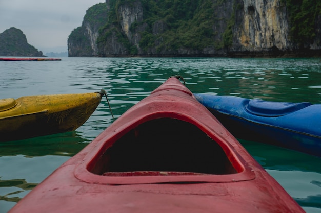 Colpo vicino di una canoa rossa sull'acqua con una montagna nella distanza