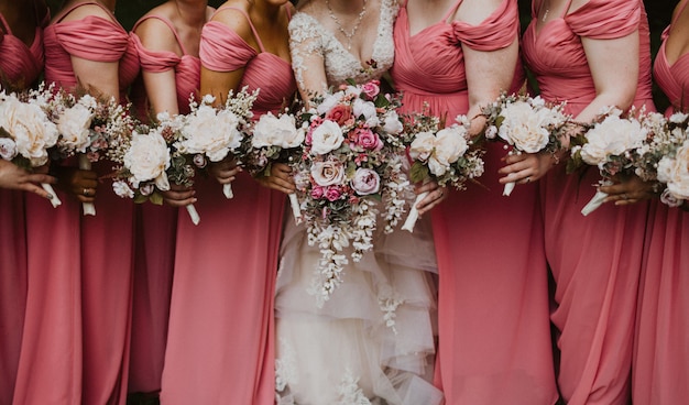 Colpo vicino di una sposa con le sue damigelle d'onore che tengono i fiori