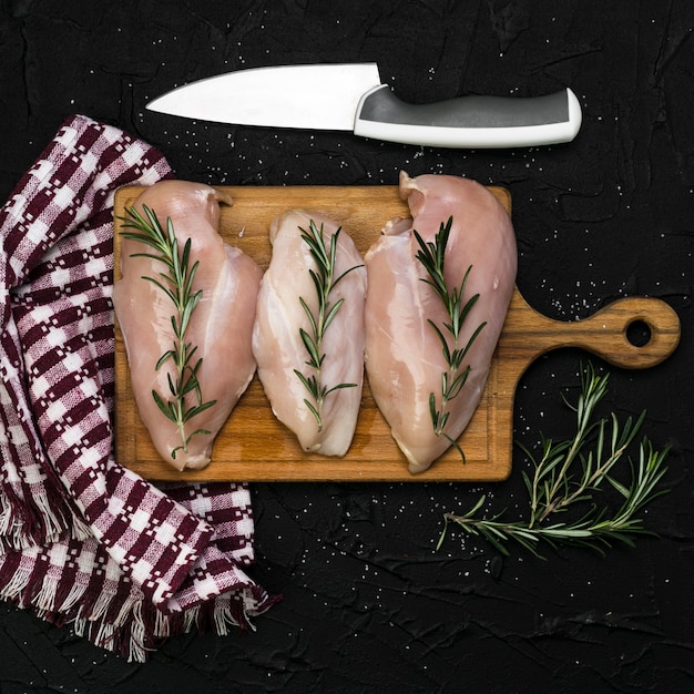 Coltello e tovagliolo vicino filetto di pollo