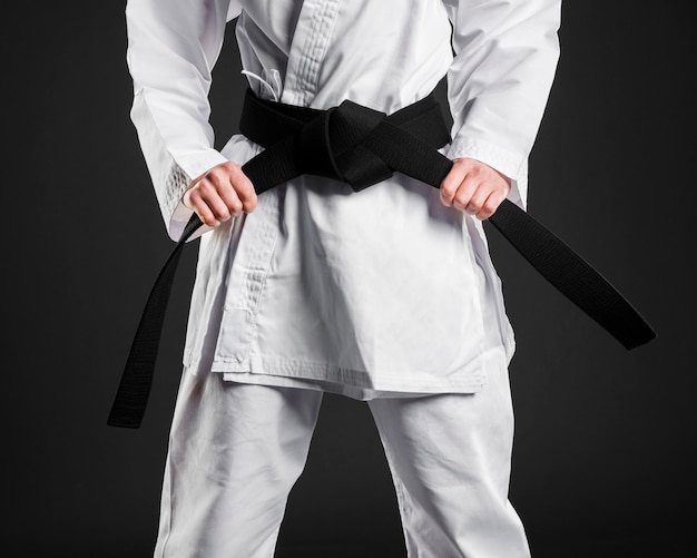 Combattente di karate con orgoglio che tiene cintura nera