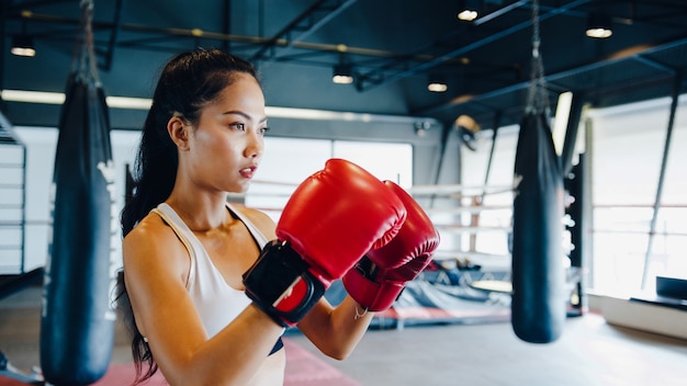 Combattente donna pratica boxe in palestra fitness class