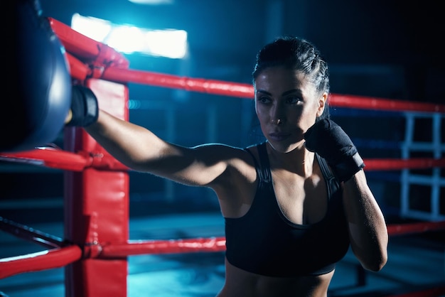 Combattente femminile che si allena in guantoni da boxe