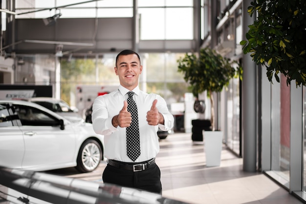 Commerciante di automobile maschio di vista frontale che mostra segno giusto