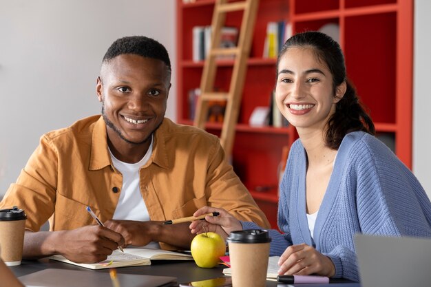 Compagni di classe che imparano e sorridono durante la sessione di studio