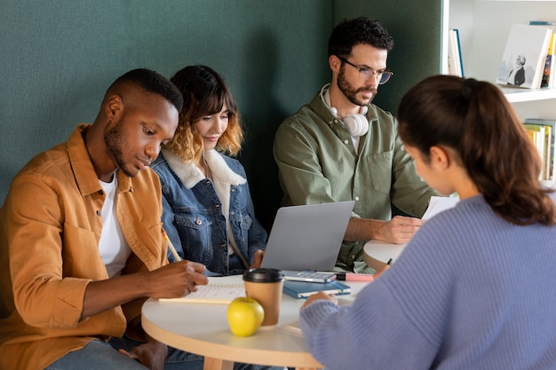 Compagni di classe che imparano insieme da appunti e laptop