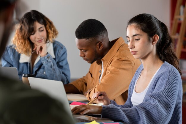 Compagni di classe che imparano insieme da laptop e appunti