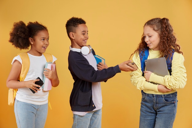 Compagni di scuola felici che tengono materiale scolastico