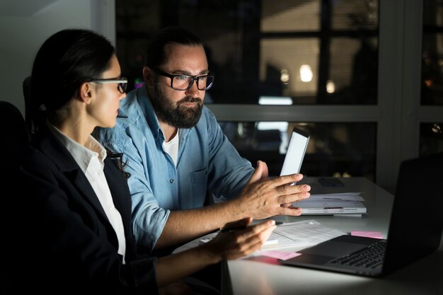 Compagni di squadra di lavoro che lavorano fino a tardi in ufficio