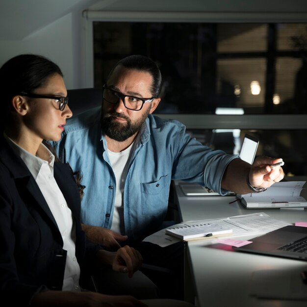 Compagni di squadra di lavoro che lavorano fino a tardi in ufficio