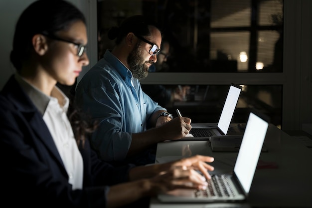 Compagni di squadra di lavoro che lavorano fino a tardi in ufficio