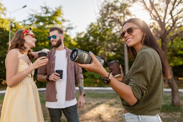 Compagnia di amici che si divertono insieme nel parco ascoltando musica