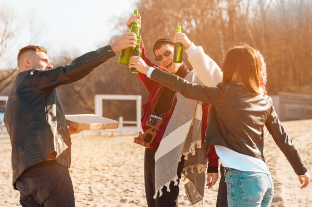 Compagnia di amici sorridenti divertendosi con la birra all&#39;aria aperta